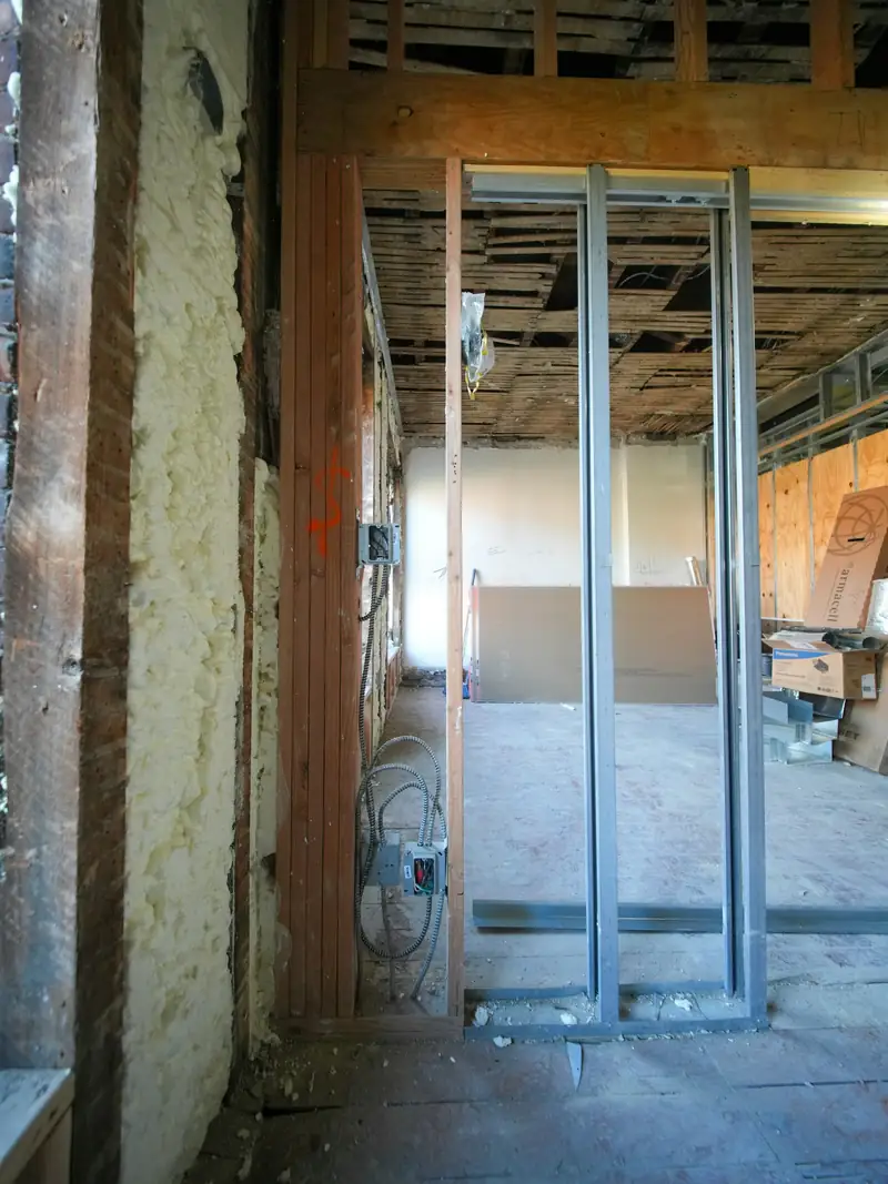 Montants métalliques d’une future cloison dressés au milieu d’une pièce en rénovation