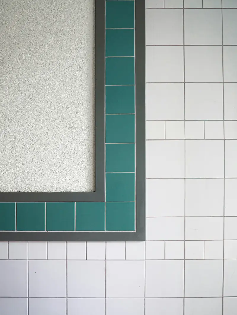 Carrelage blanc bordé d’une frise de carreaux vert jade